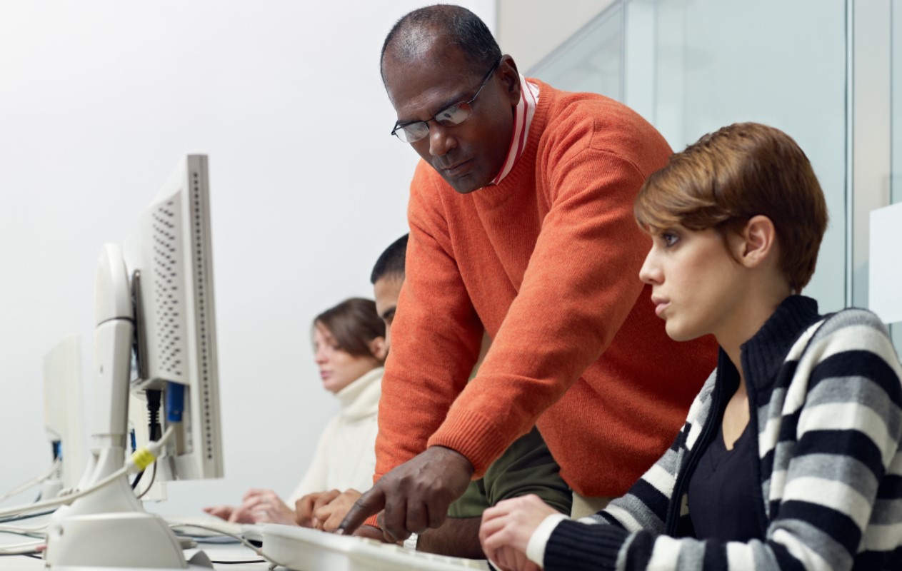 An instructor helping a computer student