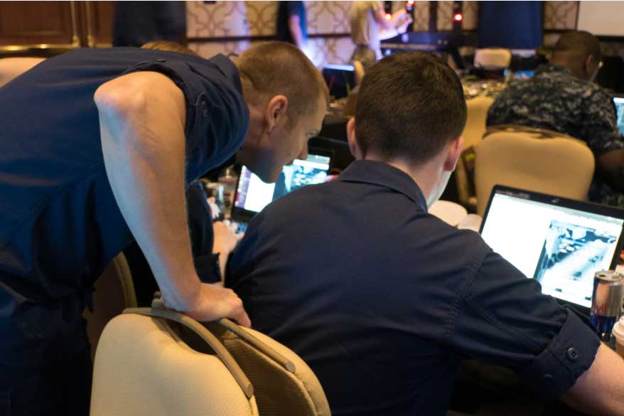 Two individuals working on a laptop